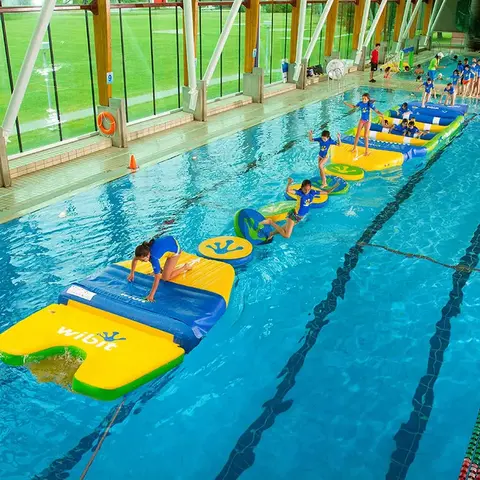 Mange bar som leker på en Wibit FastTrack vannhinderløype